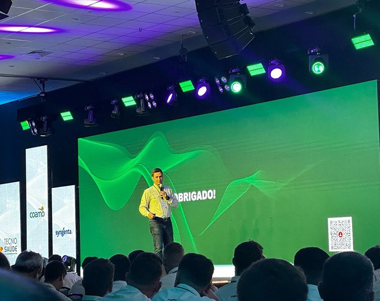 Um homem em cima de um palco dando uma palestra sobre gestão.